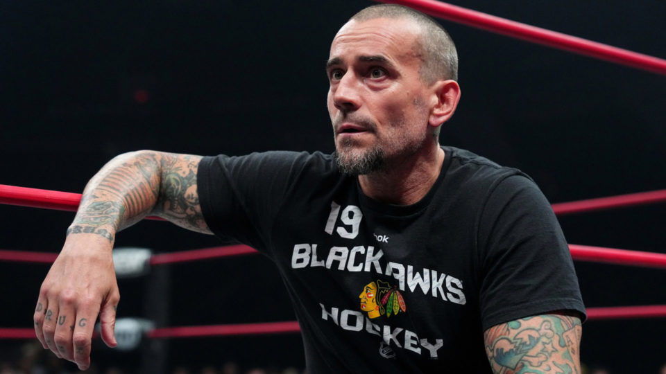 CM Punk sitting on the ring apron in AEW